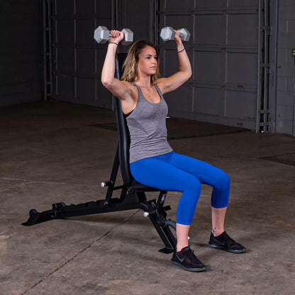 A woman performing an overhead press with dumbbells while seated on the Body-Solid Pro ClubLine Adjustable Bench SFID325 in a gym setting.