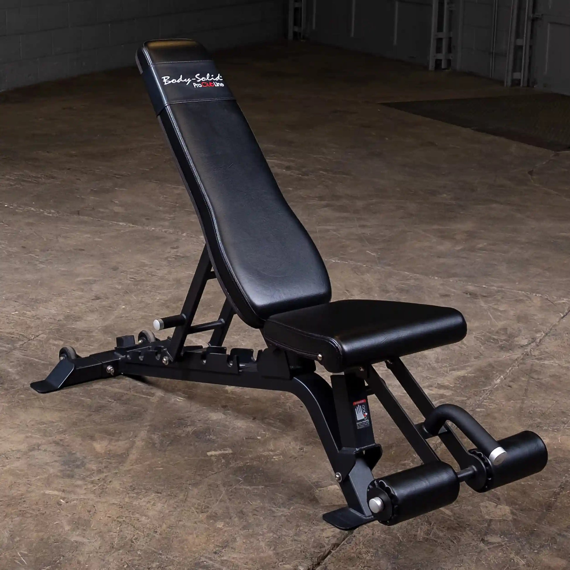 Body-Solid Pro ClubLine Adjustable Bench SFID425 positioned on a concrete floor, featuring a black padded seat and backrest with adjustable settings for various exercises.