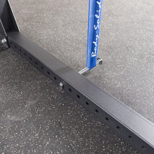 Close-up view of the Body-Solid Pro ClubLine Band Pegs Attachment SPRBP, showcasing its mounting on a metal framework with multiple adjustment holes on a gym floor.