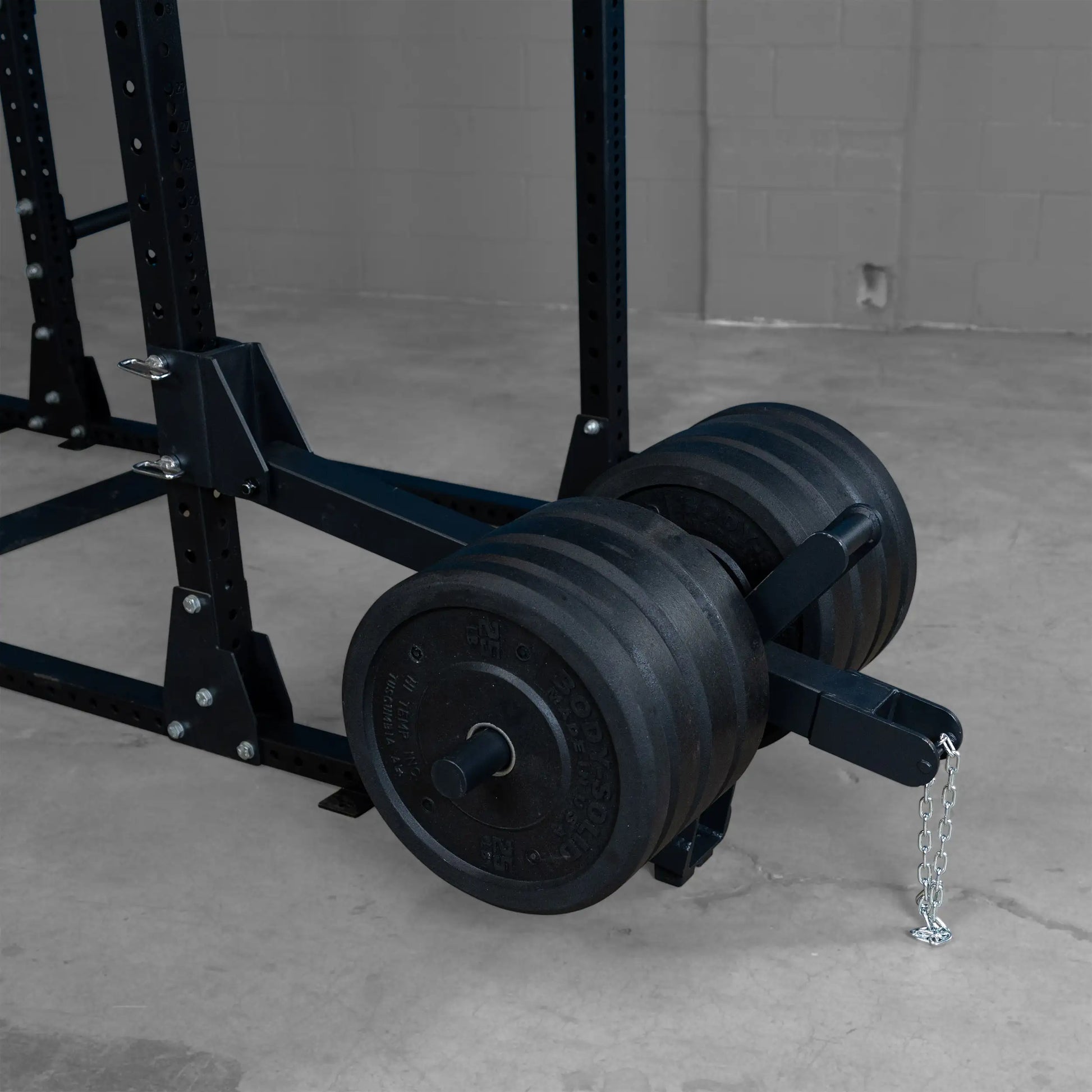 Close-up of the Body-Solid Pro ClubLine Belt Squat Attachment SPRBSA with weight plates attached, showcasing its sturdy construction and design, set against a neutral background.