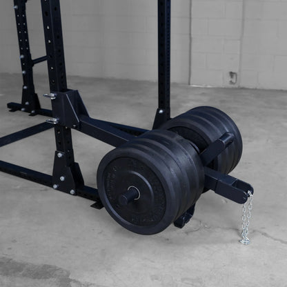 Body-Solid Pro ClubLine Belt Squat Attachment SPRBSA featuring a metallic frame and heavy black weights positioned on a gym floor.