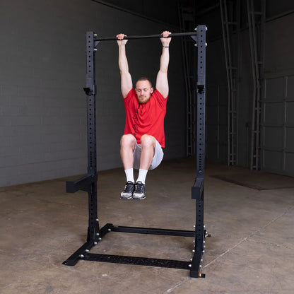 Man performing a hanging leg raise on a Body-Solid Pro ClubLine Commercial Half Rack SPR500 in a gym setting.
