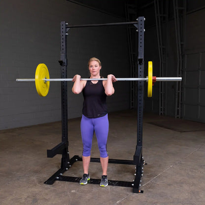 A person performing a barbell shoulder lift in a gym using the Body-Solid Pro ClubLine Commercial Half Rack SPR500.