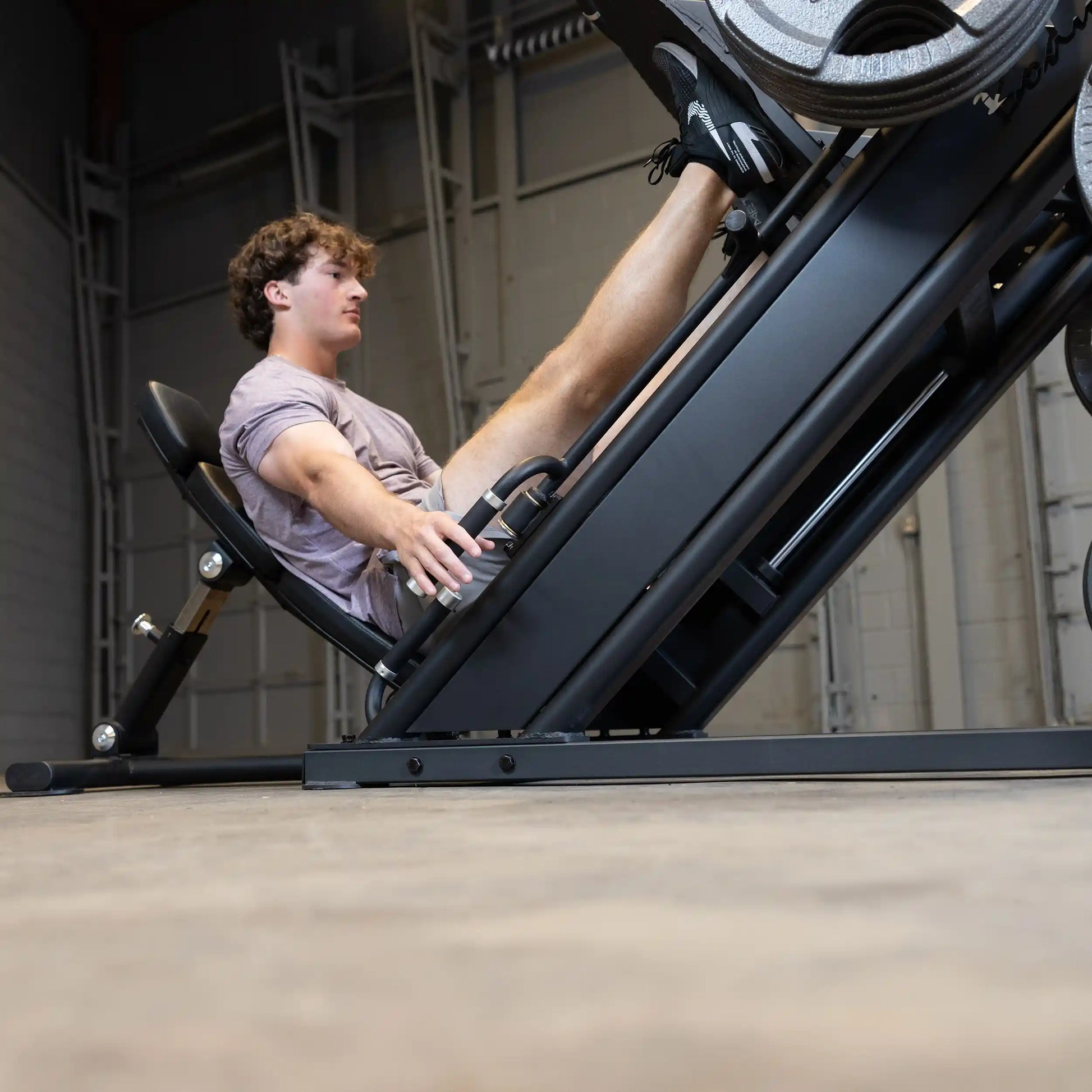 A person using the Body-Solid Pro ClubLine Commercial Leg Press Machine SGLP500 in a gym setting, focusing on leg exercises.