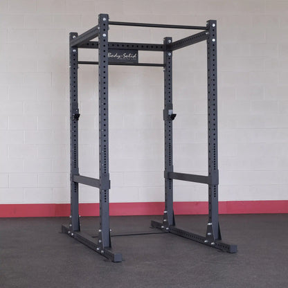 Body-Solid Pro ClubLine Commercial Power Rack SPR1000 in a gym setting against a light-colored brick wall.