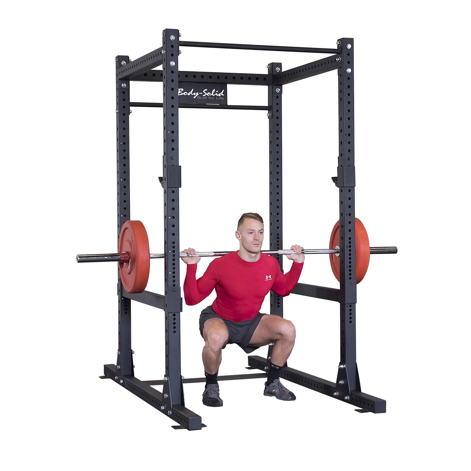 A person performing a squat exercise with a barbell on the Body-Solid Pro ClubLine Commercial Power Rack SPR1000.