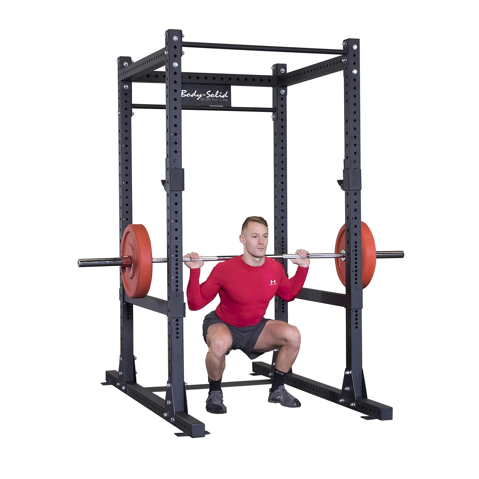 A person performing a squat exercise with a barbell on the Body-Solid Pro ClubLine Commercial Power Rack SPR1000.