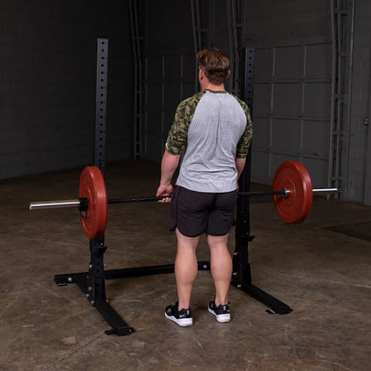 Man lifting weights on a Body-Solid Pro ClubLine Commercial Squat Stand SPR250 in a gym setting.