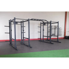 Body-Solid Pro ClubLine Double Extended Commercial Power Rack SPR1000DBBACK in a gym setting, featuring a sturdy double rack structure with multiple adjustment points and storage for weights.