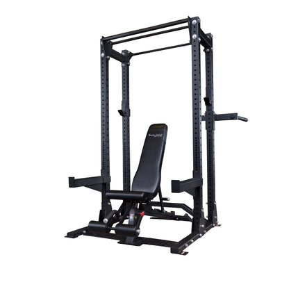 An image of the Body-Solid Pro ClubLine Extended Commercial Half Rack SPR500BACK, featuring a sturdy black frame with adjustable components and an incline bench set inside.