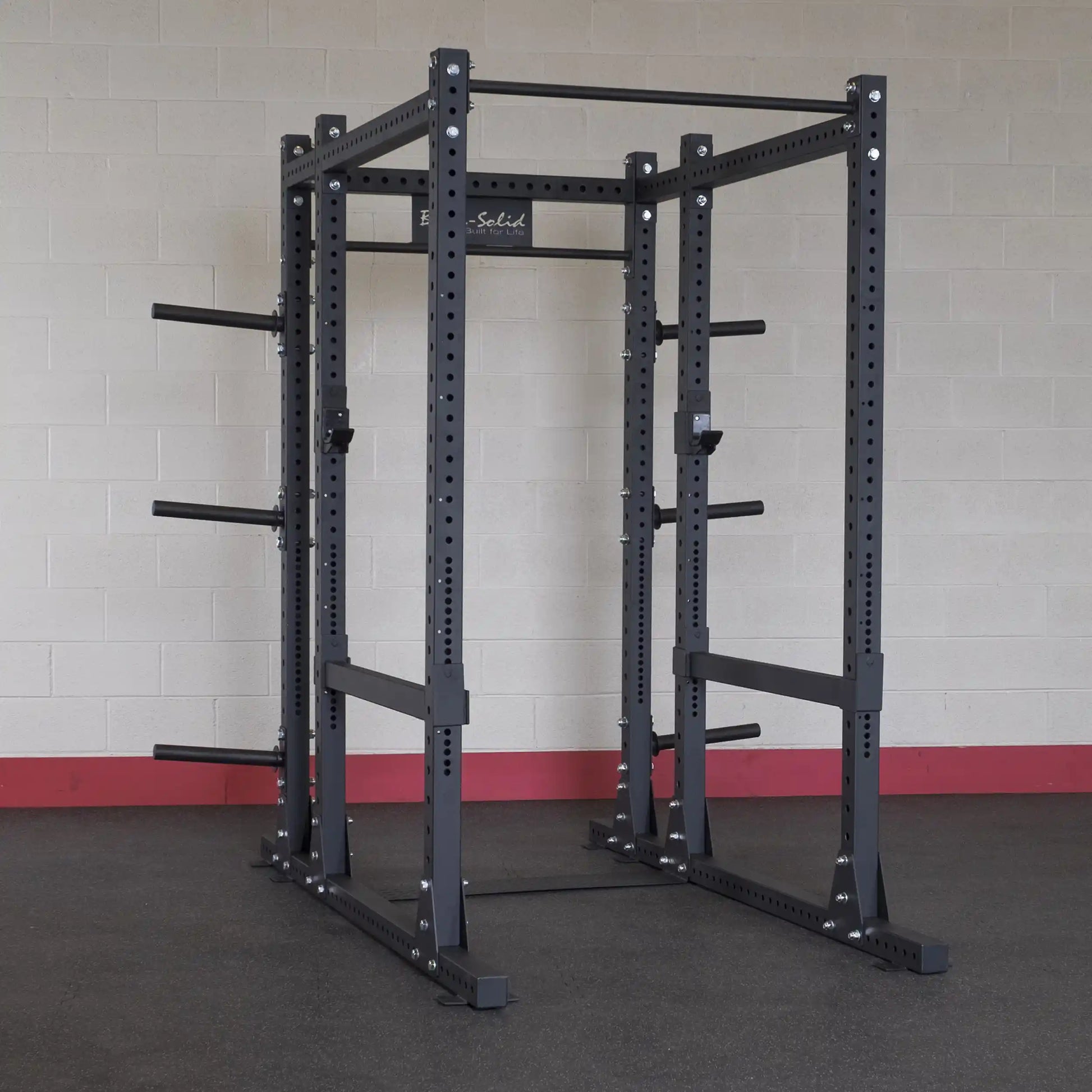 Body-Solid Pro ClubLine Extended Commercial Power Rack SPR1000BACK in a gym setting against a light-colored brick wall.