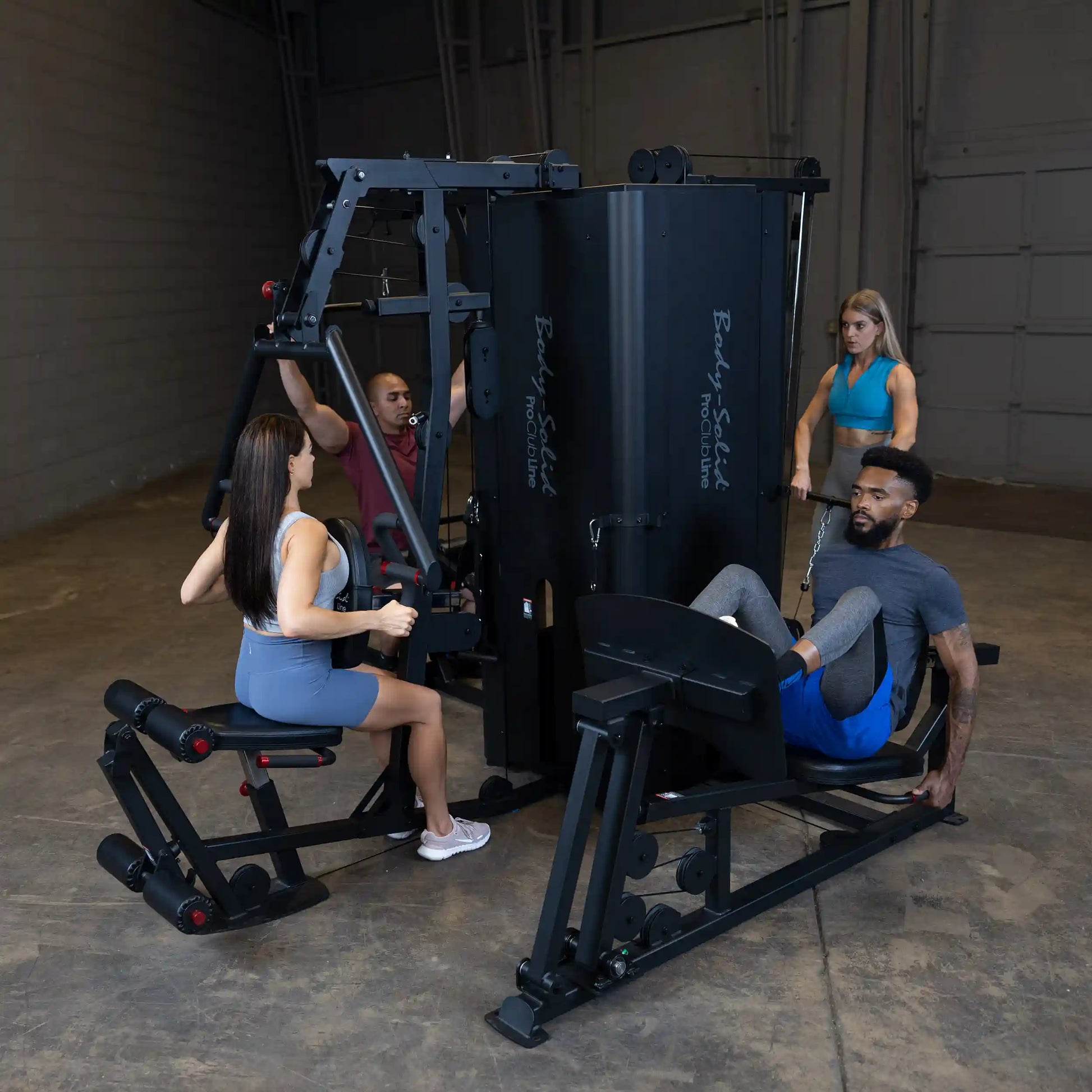 Group of four individuals using the Body-Solid Pro ClubLine Four-Stack Gym S1000 in a fitness studio, engaging in different exercises.
