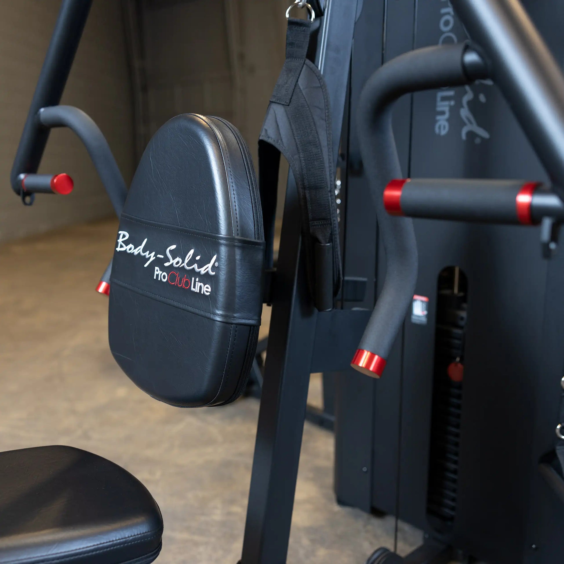 Close-up view of the Body-Solid Pro ClubLine Four-Stack Gym S1000, featuring a padded seat and handles, set in a gym environment.