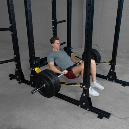 A person using the Body-Solid Pro ClubLine Hip Thrust Attachment SPRHT in a gym setting, performing hip thrusts with a weighted barbell.