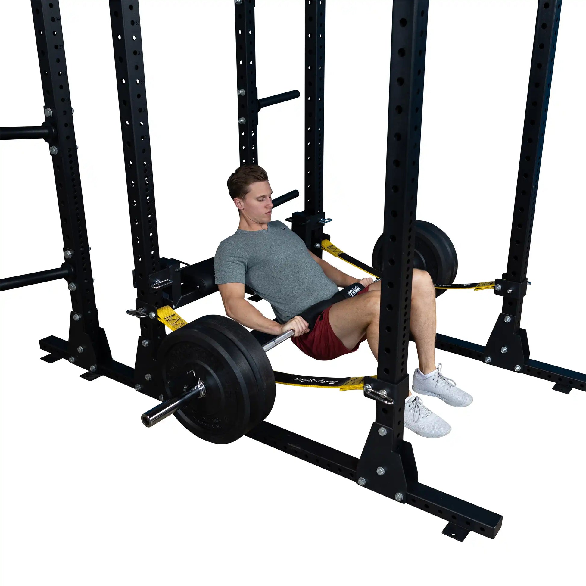 Image of a person performing a hip thrust using the Body-Solid Pro ClubLine Hip Thrust Attachment SPRHT, with a barbell loaded with weights, in a gym setting.