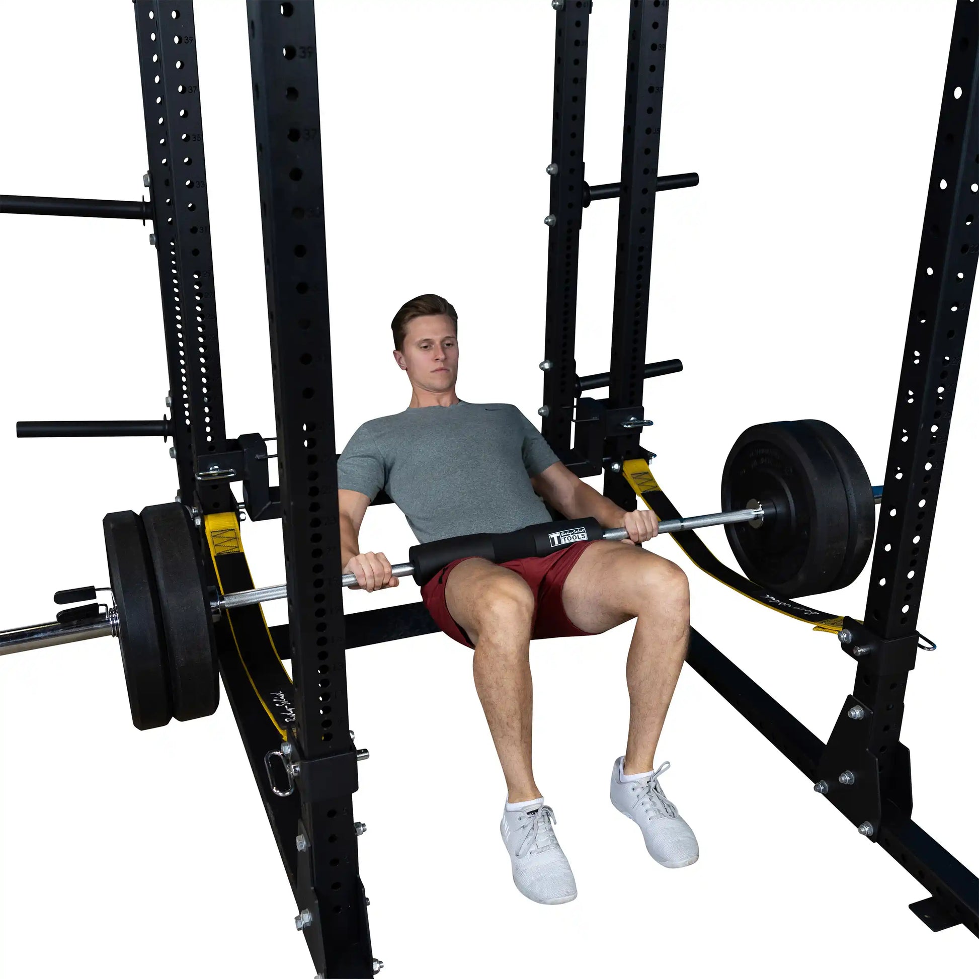 A male athlete demonstrating the Body-Solid Pro ClubLine Hip Thrust Attachment SPRHT while performing a hip thrust exercise with weights in a gym setting.