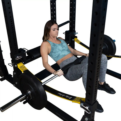 A woman performs a hip thrust using the Body-Solid Pro ClubLine Hip Thrust Attachment SPRHT, positioned in a squat rack with weights on the barbell.