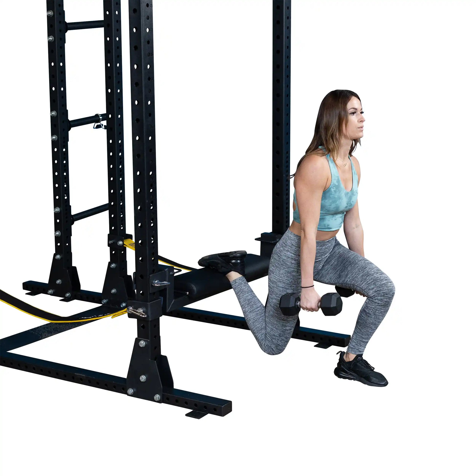 Woman performing a hip thrust exercise using the Body-Solid Pro ClubLine Hip Thrust Attachment SPRHT, holding dumbbells while positioned on a gym equipment setup.