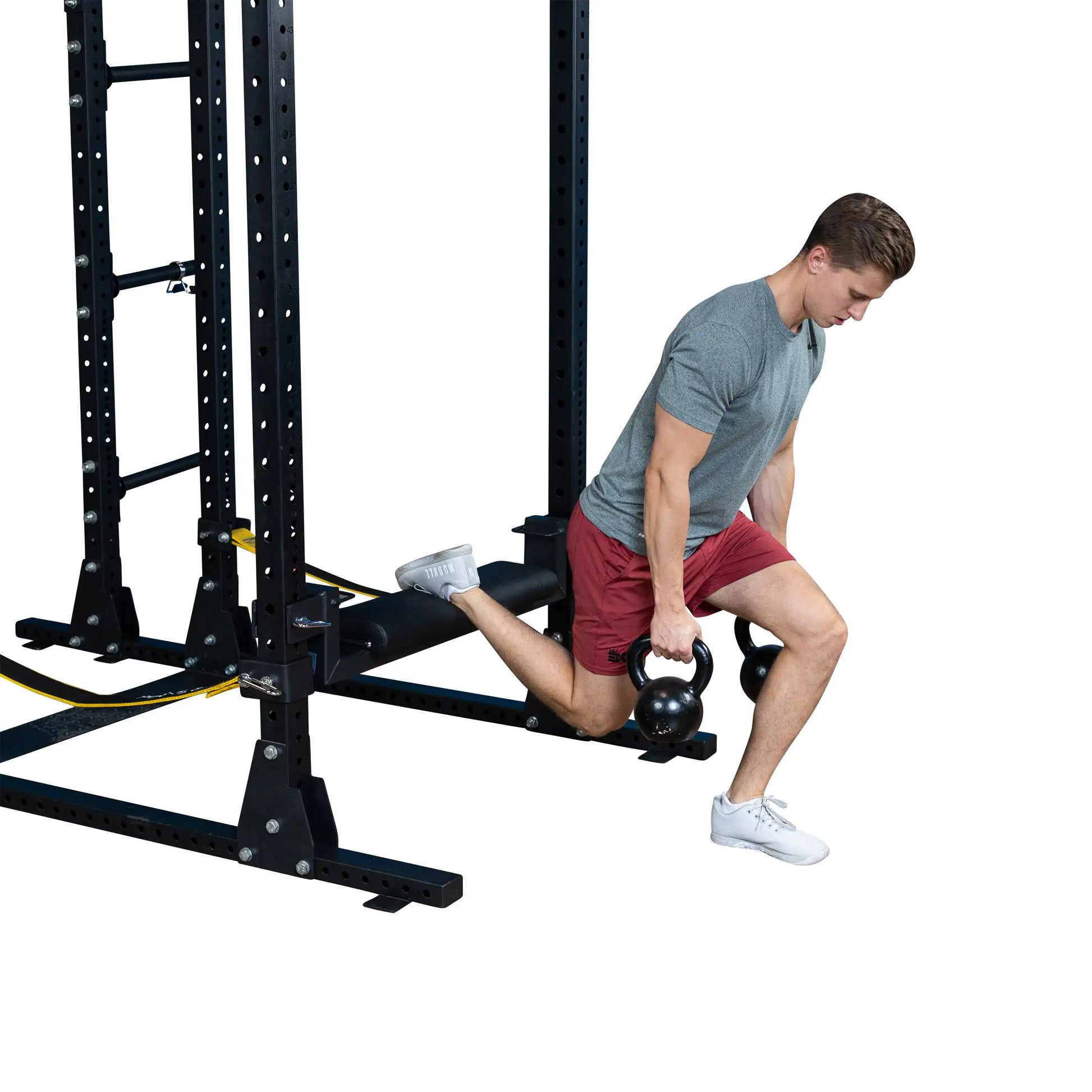 A person demonstrating an exercise using the Body-Solid Pro ClubLine Hip Thrust Attachment SPRHT, featuring a kettlebell and a gym setup.