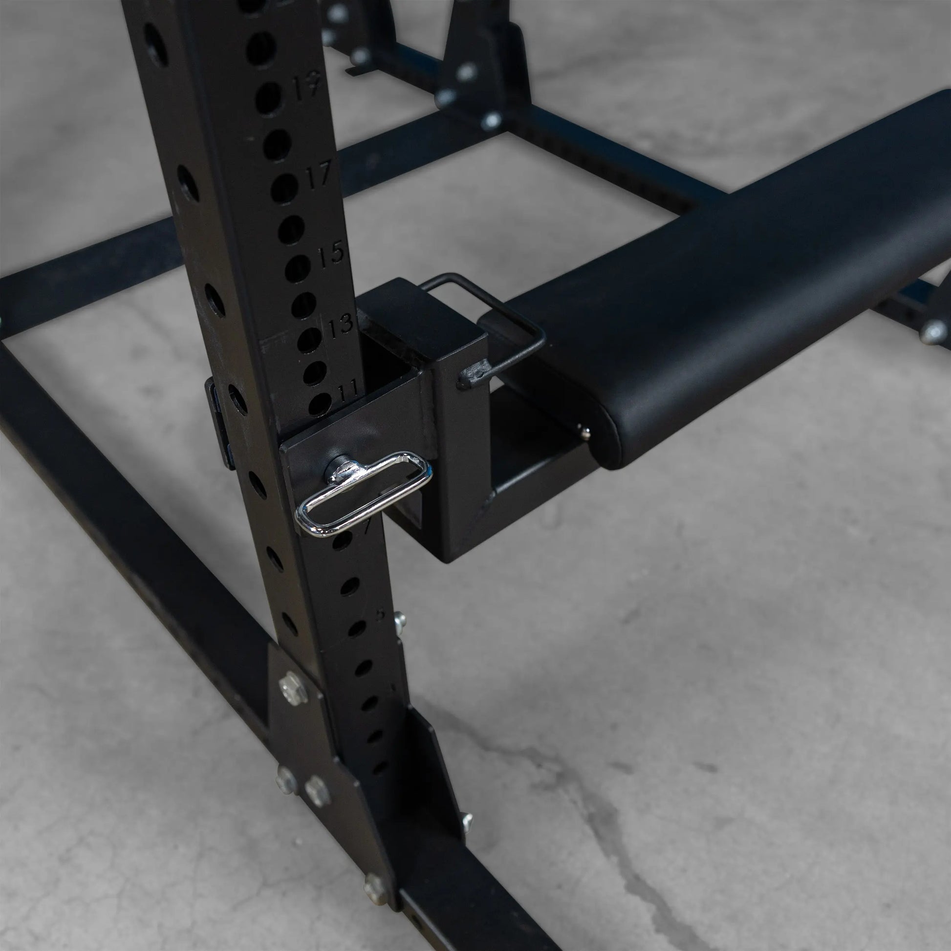Close-up view of the Body-Solid Pro ClubLine Hip Thrust Attachment SPRHT, showcasing the attachment mechanism and padded support on a gym equipment frame.