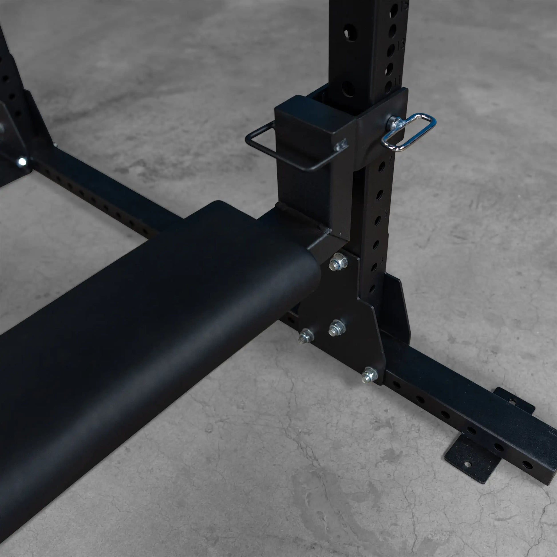 Close-up view of the Body-Solid Pro ClubLine Hip Thrust Attachment SPRHT, showcasing its padded support and mounting hardware against a concrete floor.
