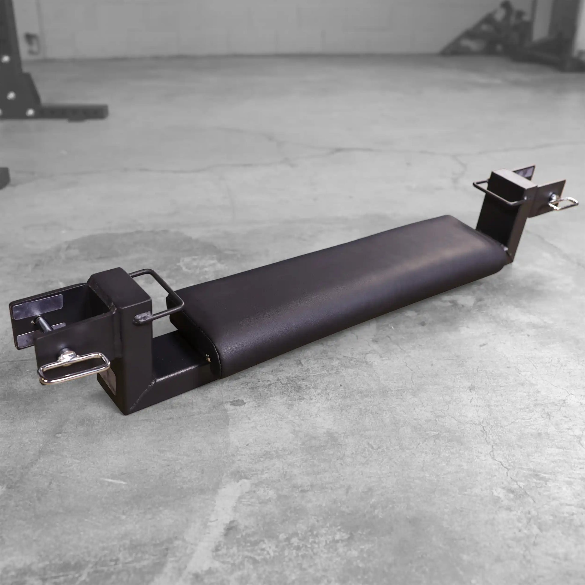 Body-Solid Pro ClubLine Hip Thrust Attachment SPRHT, featuring a padded surface and attachment points, placed on a concrete gym floor.
