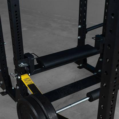 Close-up view of the Body-Solid Pro ClubLine Hip Thrust Attachment SPRHT, featuring a padded surface and attachment points for a barbell within a squat rack setup.