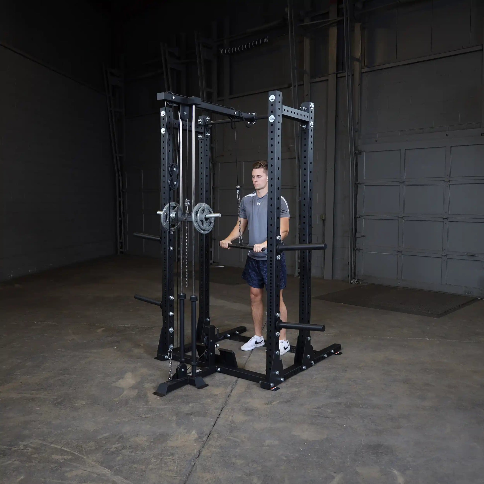 A fitness enthusiast using the Body-Solid Pro ClubLine Lat Attachment SPRHLA in a spacious gym setting, demonstrating a lat pulldown exercise.