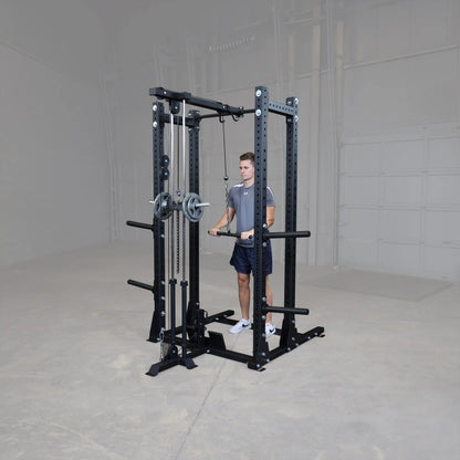 A person using the Body-Solid Pro ClubLine Lat Attachment SPRHLA, standing in front of a weight lifting station in a spacious gym environment.