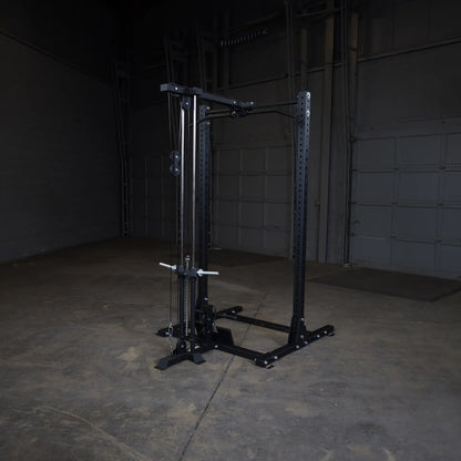 Image of a Body-Solid Pro ClubLine Lat Attachment SPRHLA, featuring a sturdy black frame and cable system, positioned in an empty gym space with concrete flooring.