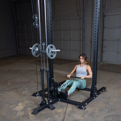 A woman using the Body-Solid Pro ClubLine Lat Attachment SPRHLA for a seated row exercise in a gym setting.