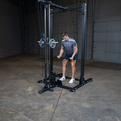 A person using the Body-Solid Pro ClubLine Lat Attachment SPRHLA for a workout, performing a lat pull-down exercise in a spacious gym environment.