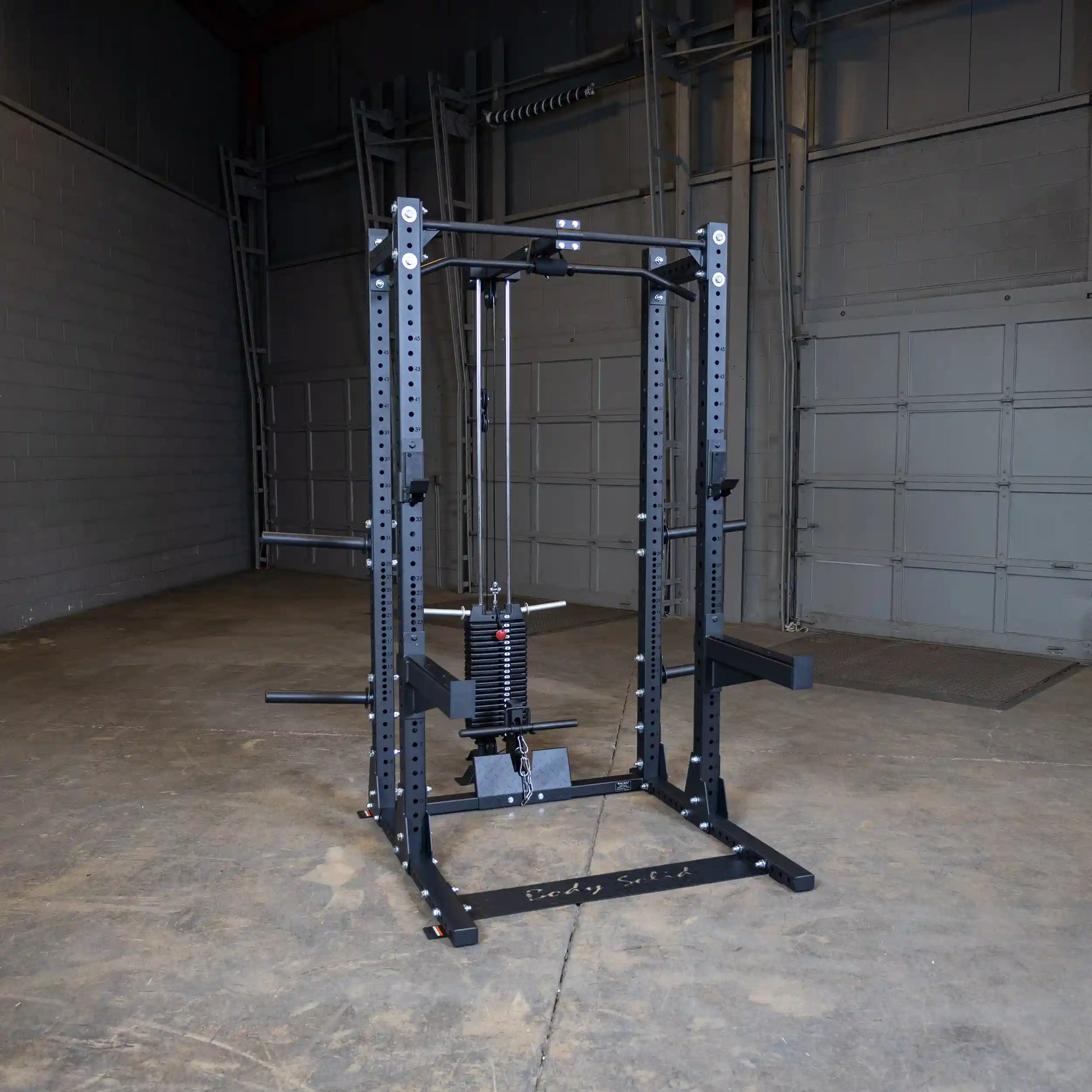 A Body-Solid Pro ClubLine Lat Attachment SPRHLA is displayed in an empty gym space, featuring a black frame with a weight stack and pulleys for lat exercises.