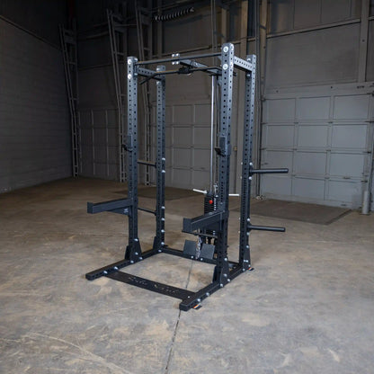 Image of a Body-Solid Pro ClubLine Lat Attachment SPRHLA mounted on a squat rack in an industrial gym setting with a concrete floor and gray walls.