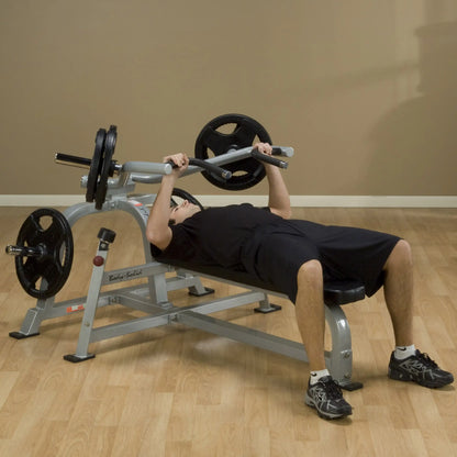 A person performing a bench press on the Body-Solid Pro ClubLine Leverage Bench Press LVBP, with weights on the bar, in a fitness setting.