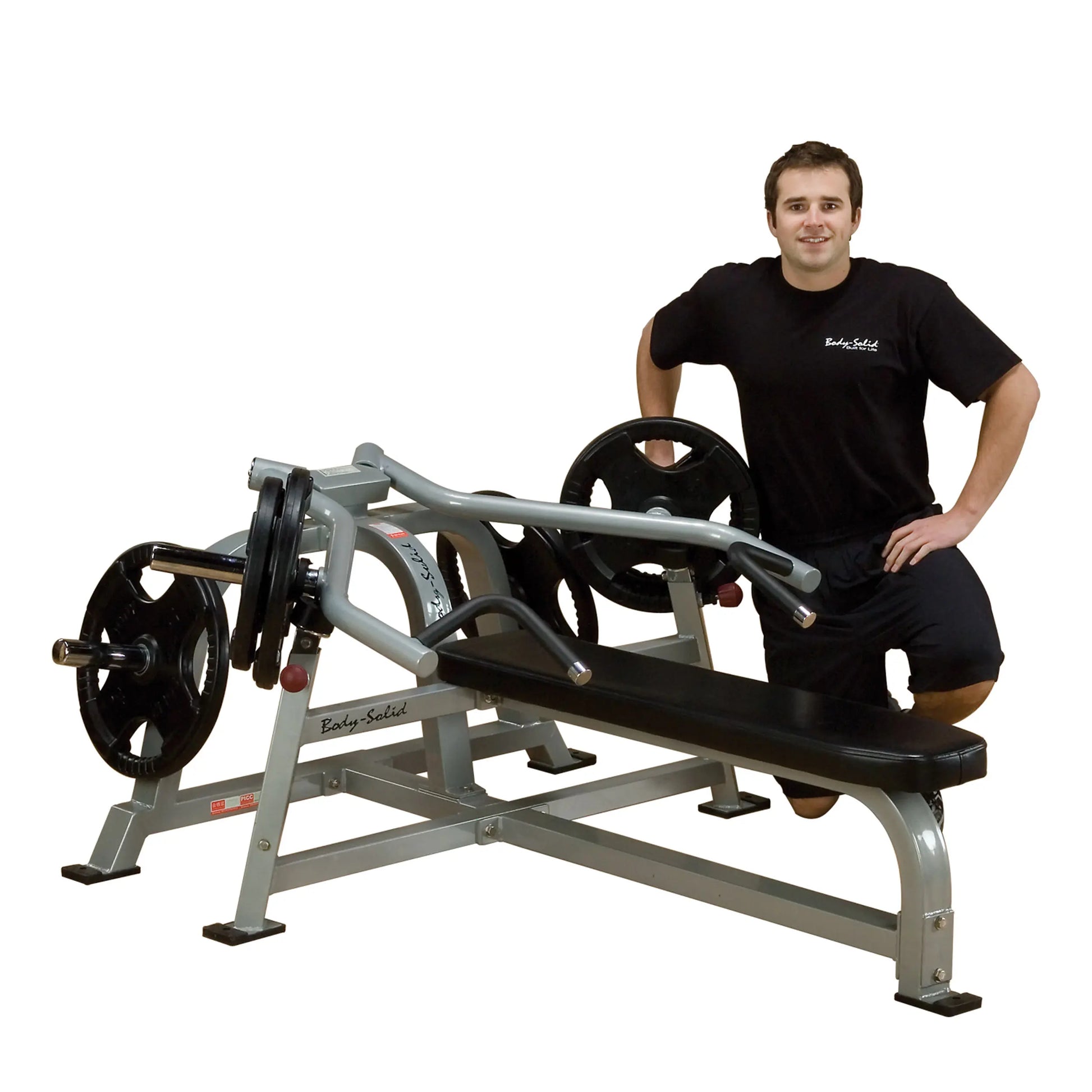 A man posing next to the Body-Solid Pro ClubLine Leverage Bench Press LVBP, showcasing its design with weight plates attached.