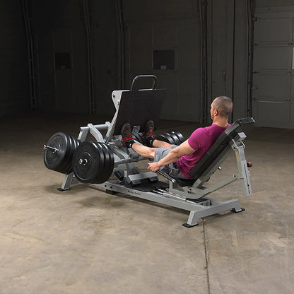 A person using the Body-Solid Pro ClubLine Leverage Horizontal Leg Press Machine LVLP in a gym setting, focusing on leg workouts with weights loaded on the machine.