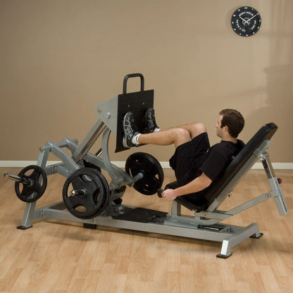 A person using the Body-Solid Pro ClubLine Leverage Horizontal Leg Press Machine LVLP in a gym setting, demonstrating leg press exercise with weights.
