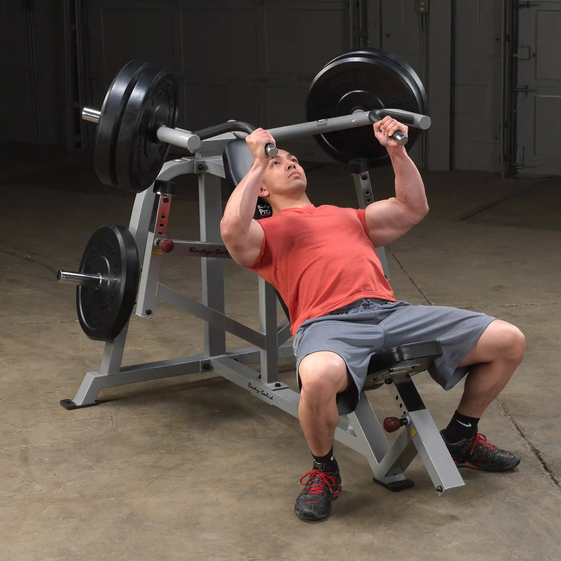 A person performing an incline press on the Body-Solid Pro ClubLine Leverage Incline Press LVIP, showcasing proper form with weights on the bar.