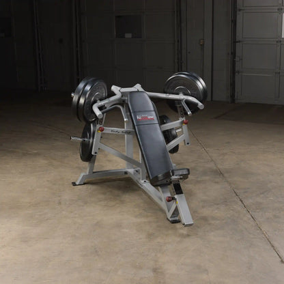 Body-Solid Pro ClubLine Leverage Incline Press LVIP, a weightlifting machine with a padded seat and adjustable arm supports, positioned in a well-lit gym space.