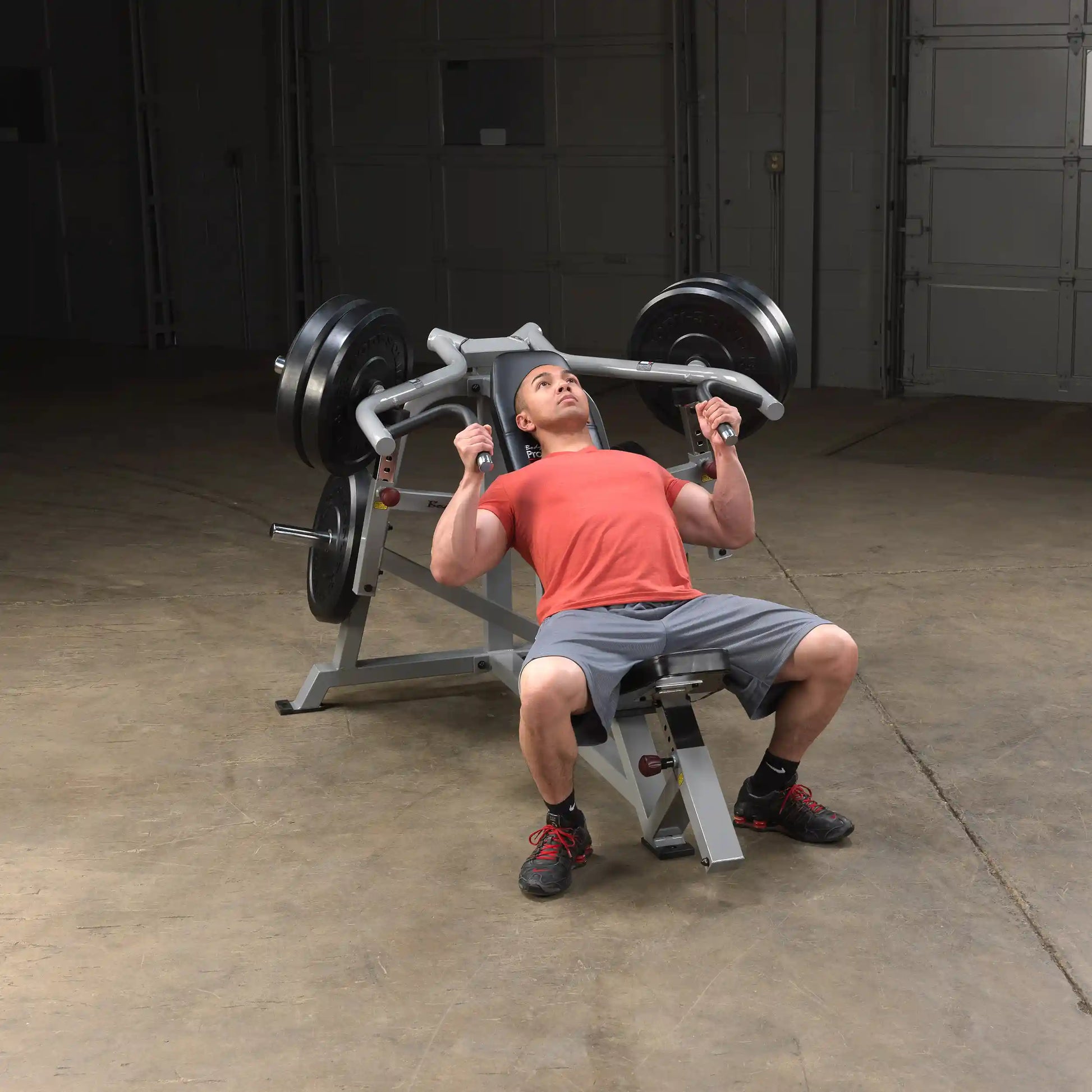 A person performing an exercise on the Body-Solid Pro ClubLine Leverage Incline Press LVIP, showcasing proper form while lifting weights in a gym setting.