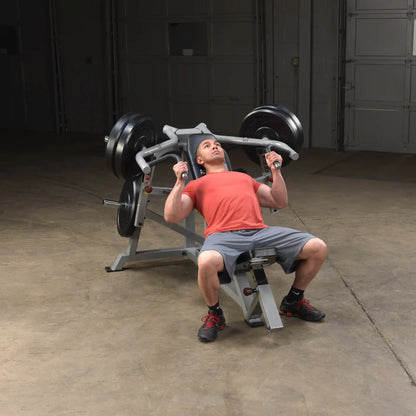 A person performing an exercise on the Body-Solid Pro ClubLine Leverage Incline Press LVIP, showcasing proper form while lifting weights in a gym setting.