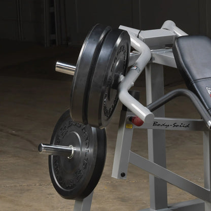 Close-up of the Body-Solid Pro ClubLine Leverage Incline Press LVIP, featuring weight plates and a padded seat, set in an industrial gym environment.