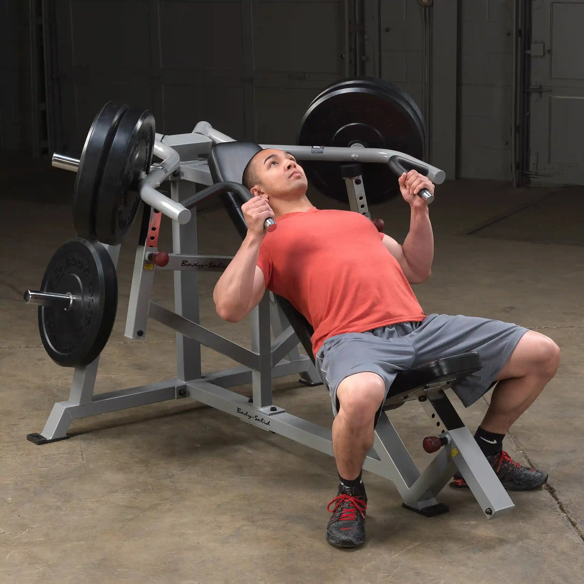 A person performing an exercise on the Body-Solid Pro ClubLine Leverage Incline Press LVIP, showcasing proper form with weights on the machine.