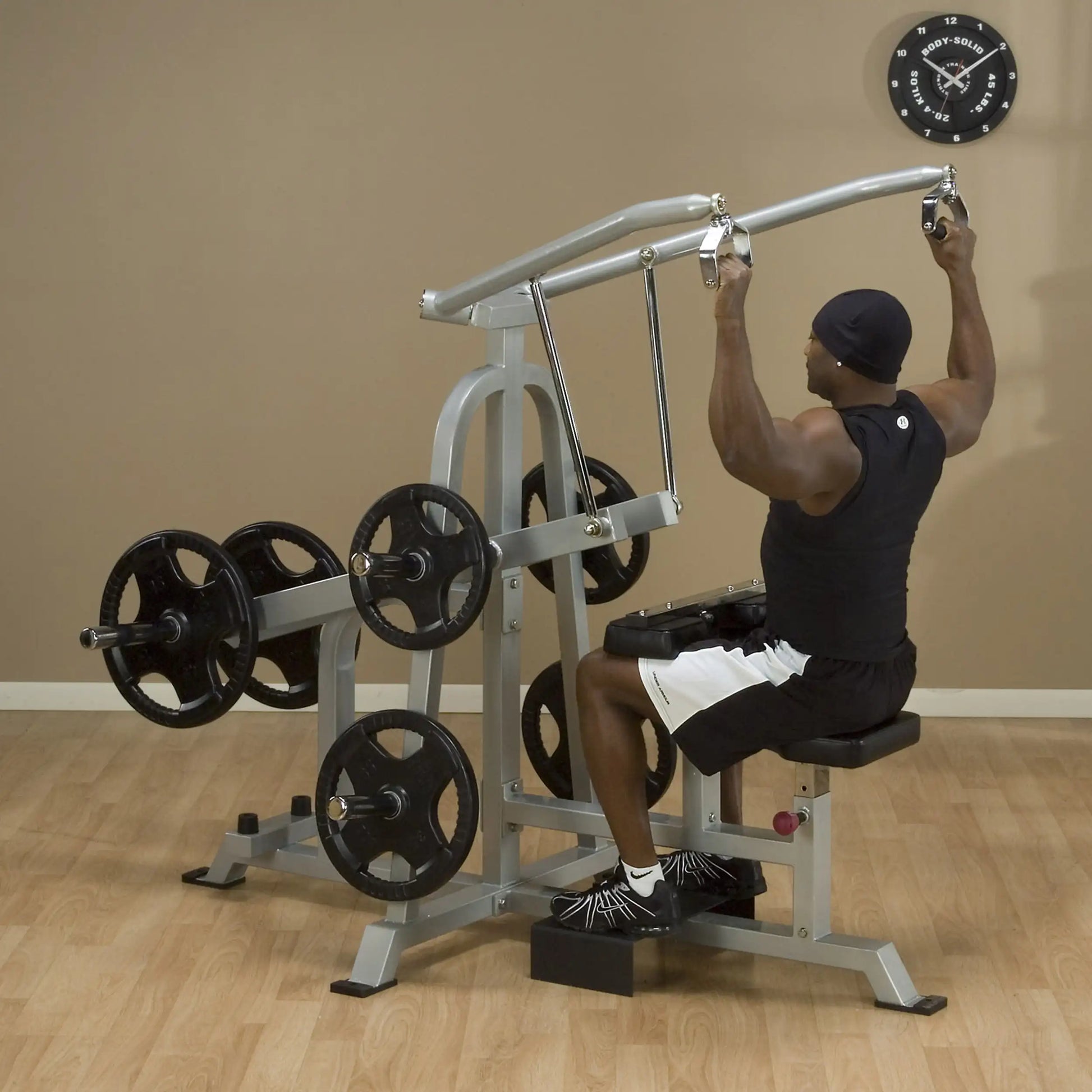 A person using the Body-Solid Pro ClubLine Leverage Lat Pulldown Machine LVLA in a gym setting, demonstrating proper form while performing a lat pulldown exercise.