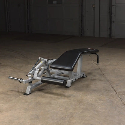 Body-Solid Pro ClubLine Leverage Leg Curl Machine LVLC positioned on a gym floor, featuring a padded black seat and leg support.