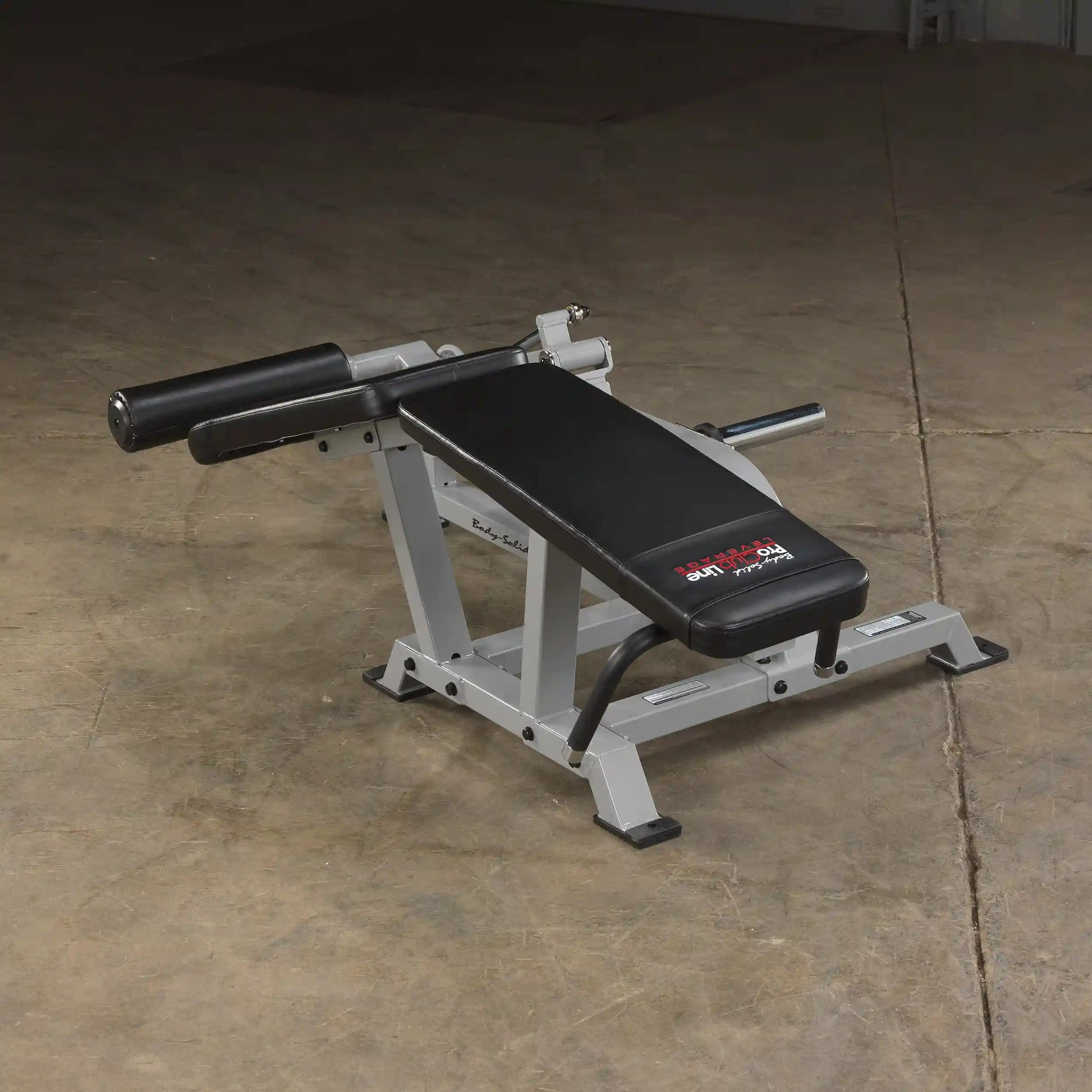 Body-Solid Pro ClubLine Leverage Leg Curl Machine LVLC positioned on a gym floor, featuring a padded seat and adjustable leg rollers.