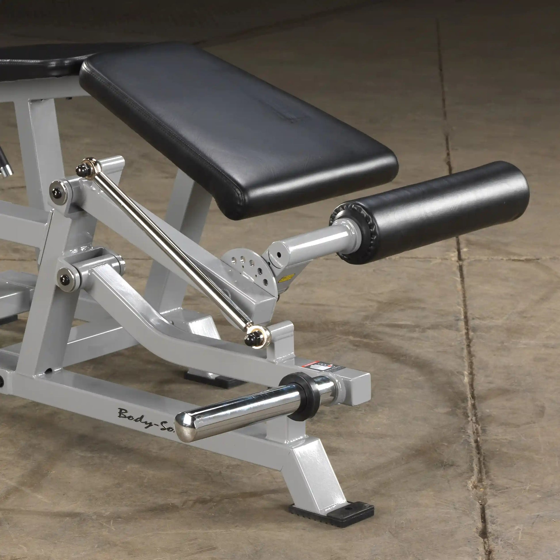 Close-up view of the Body-Solid Pro ClubLine Leverage Leg Curl Machine LVLC, showcasing the padded leg support and adjustable arm mechanism.
