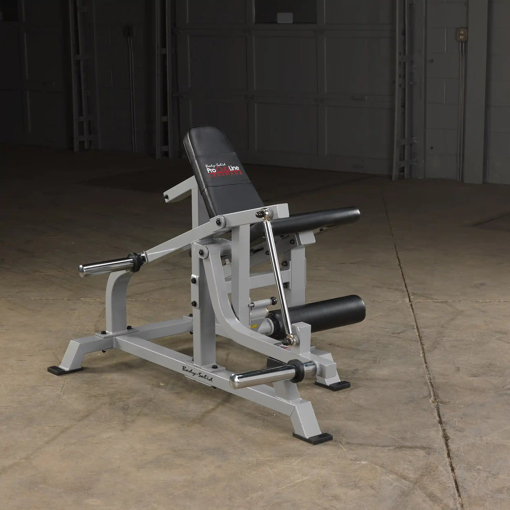 Body-Solid Pro ClubLine Leverage Leg Extension Machine LVLE positioned in a gym setting with a gray frame and black padding on the seat.