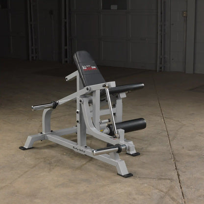 Body-Solid Pro ClubLine Leverage Leg Extension Machine LVLE positioned in a gym setting with a gray frame and black padding on the seat.
